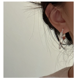 Close-up of minimalist S925 sterling silver hoop earring with chain detail on model