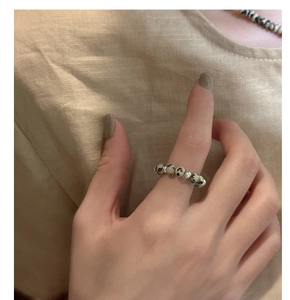 Close-up of minimalist beaded ring with spotted marble stones and silver spacers