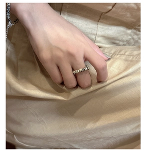 Detail of handmade S925 silver beaded ring with spotted stone on a finger