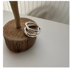 Détail de bague double couche en argent S925 avec texture ondulée sur support bois