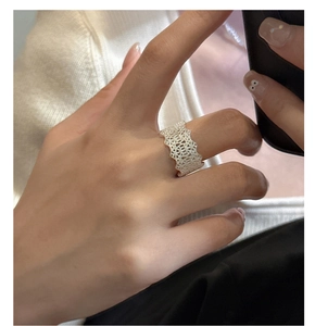 Close-up of S925 sterling silver lace ring with hollow geometric patterns on finger