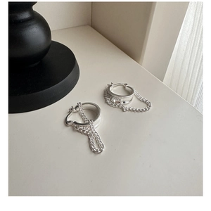 Detailed close-up of S925 sterling silver hoop earrings with dangling Cuban chain tassels