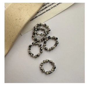 Detail of 5-piece S925 silver beaded elastic rings with grey spotted stone textures