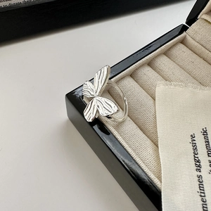 S925 sterling silver bow ring with textured wings in a jewelry box minimalist design