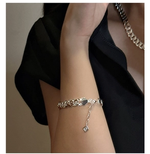 Gros plan d'un ensemble bracelet et collier maille gourmette en argent S925 sur un mannequin