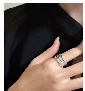 Détail macro de la bague géométrique multicouche en argent S925 sur la main d'un mannequin