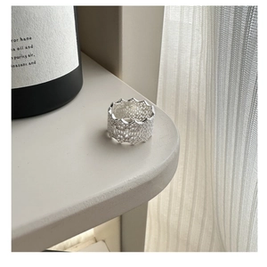 Detailed macro view of S925 sterling silver ring with intricate lace texture and wavy edges