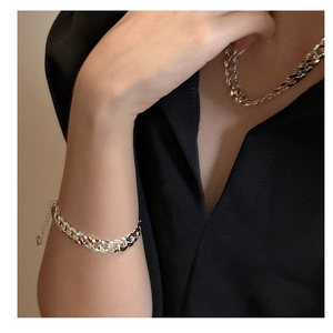 Gros plan sur l'ensemble bracelet et collier chaîne tank en argent S925 sur modèle