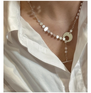 Gros plan du collier en argent S925 avec disques polis et fermoir en T sur chemise blanche