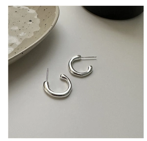Close-up of S925 sterling silver C-shaped earrings with a minimalist liquid metal texture