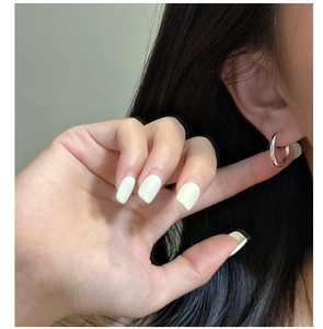 Minimalist silver C-shape hoop earrings worn by a model showing modern polished finish