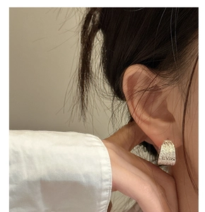 Gros plan d'une boucle d'oreille créole en argent S925 avec motif floral sur le mannequin