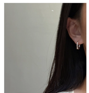 Close-up of double hoop S925 sterling silver earrings worn by model with mirror polish
