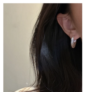 Close-up of minimalist S925 sterling silver multi-layer curved hoop earrings worn by a model