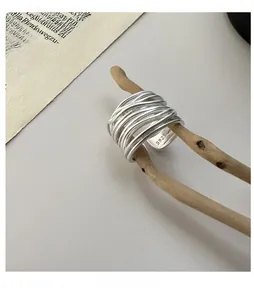Detailed view of S925 sterling silver multi-layer wrapped ring with matte finish on wood
