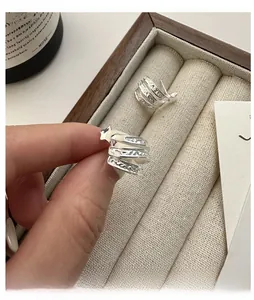 Détail de boucles d'oreilles étoile en argent S925 avec motif en spirale et texture
