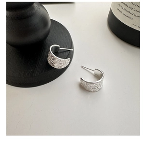 Gros plan de boucles d'oreilles C en argent sterling S925 avec motifs floraux vintage