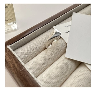 Macro shot of silver heart ring on a premium wooden jewelry box with elegant decor