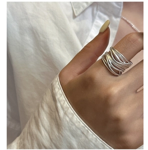 Macro shot of silver multi-layer winding ring showing intricate woven texture and matte finish