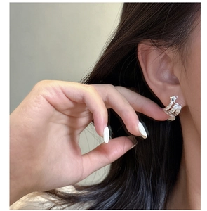 Détail macro de boucles d'oreilles étoile en argent avec un design texturé multicouche rétro