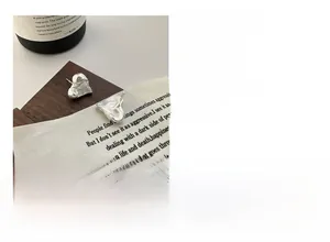 Macro view of textured S925 sterling silver heart earrings with lava style surface