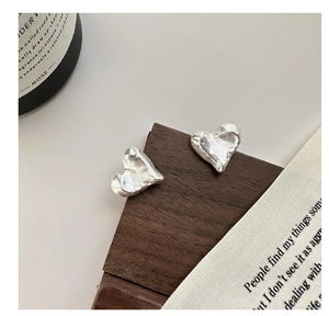 Macro shot of S925 sterling silver heart earrings with textured hammer finish detail