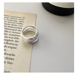 Macro detail of multi-layer matte silver wrap ring on vintage book pages
