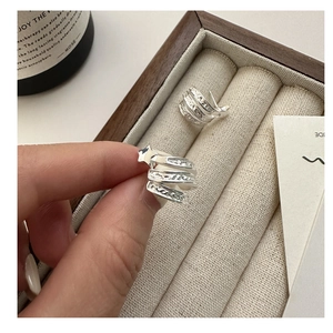 Détail macro de boucles d'oreilles étoile en argent S925 avec texture gravée vintage