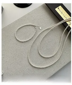 Detailed macro view of S925 sterling silver heart tag on elegant pearl necklace set