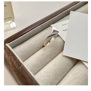 Macro shot of minimalist S925 sterling silver heart ring in a luxury wooden jewelry box