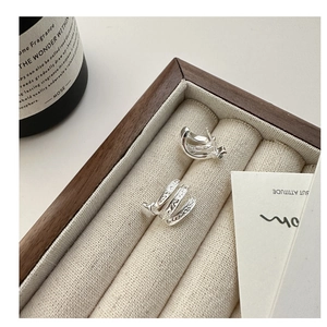 Vue détaillée des boucles d'oreilles multicouches en argent S925 dans un coffret en bois