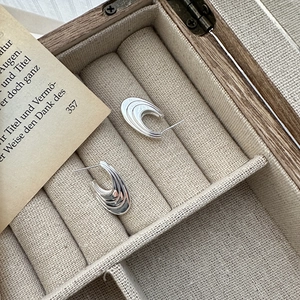 Minimalist S925 sterling silver curved hoop earrings with layered wavy texture in a jewelry box