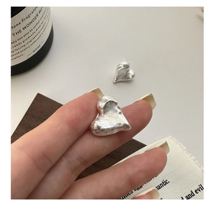 Detail of S925 sterling silver heart earrings with unique irregular lava texture