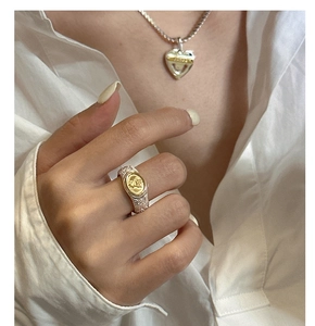 Close-up of vintage engraved silver ring and heart pendant necklace on a model