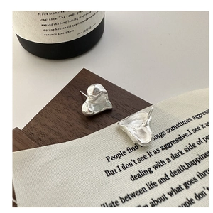 Detail of S925 sterling silver heart earrings featuring textured lava finish surface