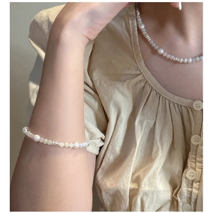 Detail of s925 sterling silver pearl necklace and bracelet set worn by a model