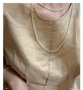 Detail view of layered 925 silver pearl necklaces and matching bracelet on a model