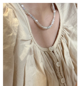 Detail of S925 silver necklace with baroque pearls and colorful beads on a model
