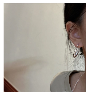 Boucles d'oreilles créoles polies en argent sterling S925 portées par un mannequin chic