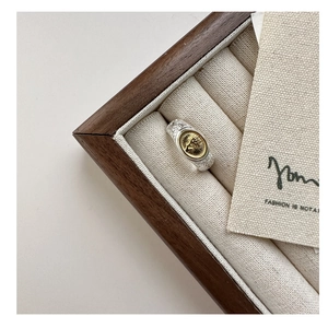 Macro view of retro coin ring with tree of life engravings in a wooden jewelry box