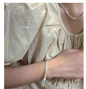 Detail of s925 silver pearl and blue stone necklace with heart pendant on model