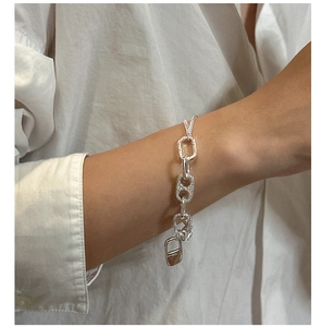 Macro shot of S925 sterling silver chain bracelet with textured links on a model wrist