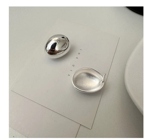 Macro detail of S925 sterling silver oval stud earrings with polished and matte finishes