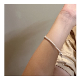 Close-up of elegant white pearl bracelet with silver clasp on woman's wrist