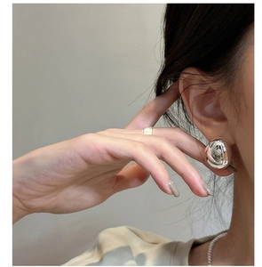 Macro view of polished silver ball stud earring showing high-gloss mirror finish metal