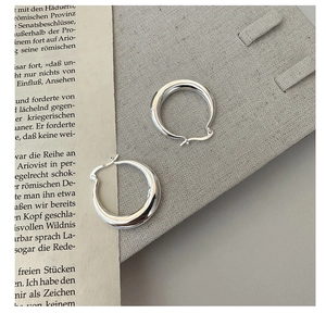 Gros plan détaillé des créoles épaisses en argent sterling S925 avec design poli en C
