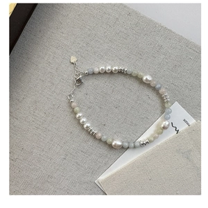 Detail of S925 silver clasp with heart charm on pearl and gemstone beaded bracelet