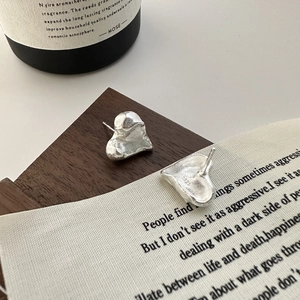 S925 sterling silver heart earrings with lava texture shown on vintage wood and linen
