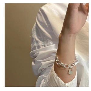Detailed view of silver chain bracelet with OT toggle clasp on model wearing a white shirt