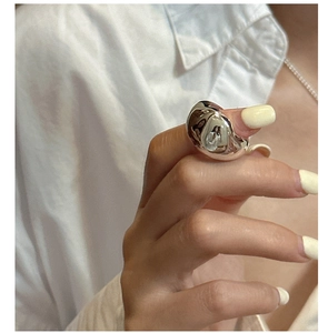 Detail view of wide irregular silver ring featuring minimalist liquid molten metal design